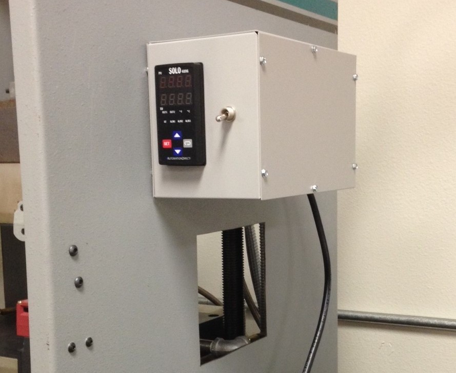 PID temperature controller and custom-designed panel in an enclosure.